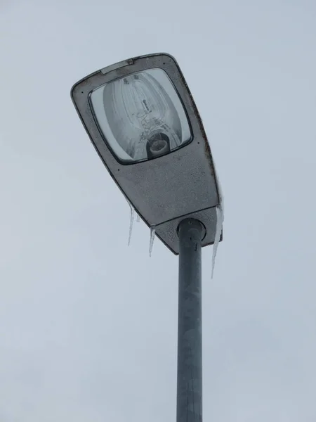 Icicles on a lamp post shot from below.