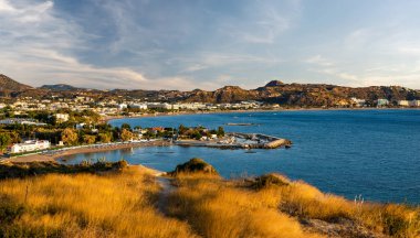 Rodos 'taki Faliraki tatil köyünün panoraması. Deniz, sahil ve çevresindeki tepeler.