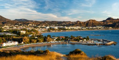 Rodos 'taki Faliraki tatil köyünün panoraması. Deniz, sahil ve çevresindeki tepeler.