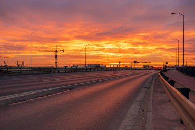 Muhteşem bir gündoğumu sırasında şehir boyunca uzanan otoyol.