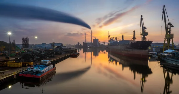 panorama of the industrial landscape - a smoking power plant, a bulk cargo ship in a shipyard, a scrap recycling station