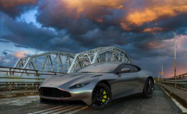 Aston Martin DB 11 bir akşam fırtınası sırasında köprüde eski usul duruyor.