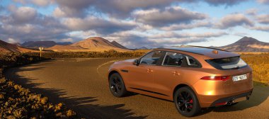Jaguar F-Pace SUV Lanzarote 'un volkanik arazisinden geçen yolda.