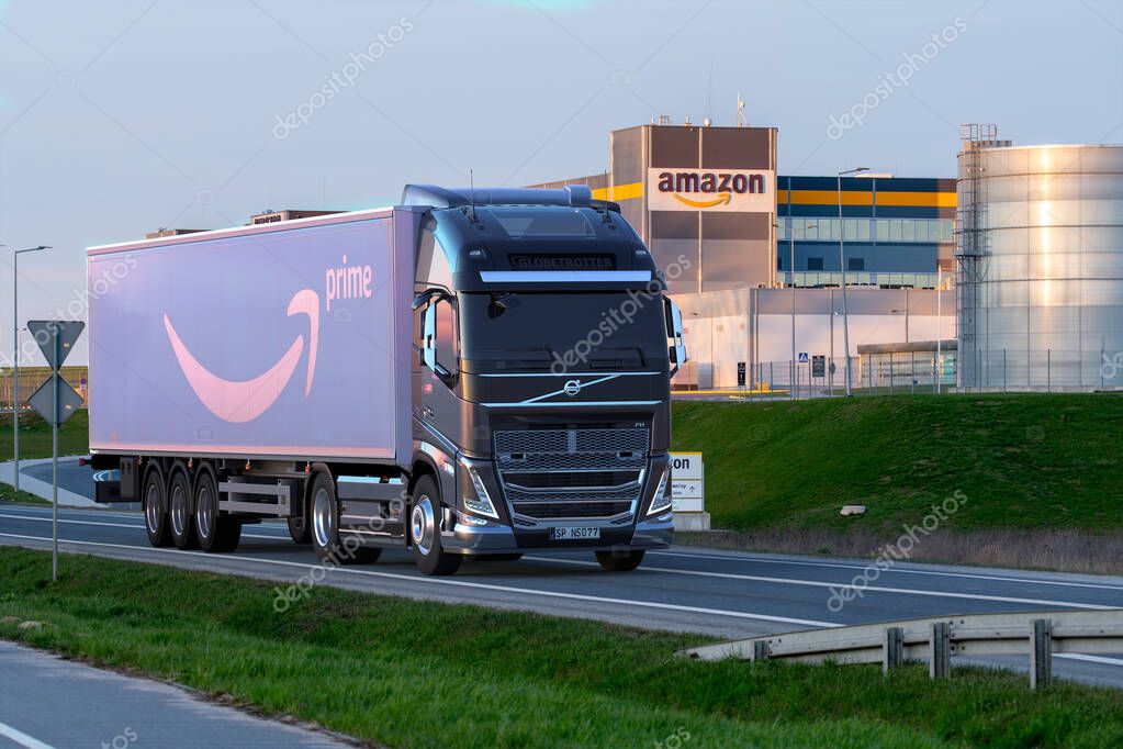 Truck with a semi-trailer with the Amazon logo going to Amazon's logistics center
