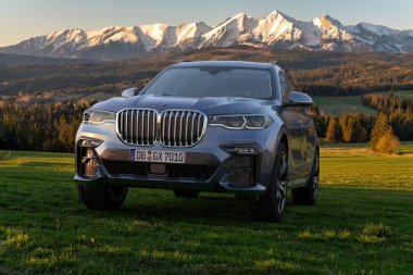Dağ zirvelerinin arka planına karşı lüks BMW X7