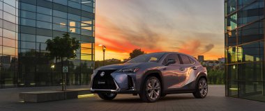 Modern bir ofis binasının otoparkında lüks bir Lexus UX geçidi.