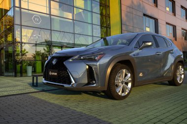 Modern bir ofis binasının otoparkında lüks bir Lexus UX geçidi.