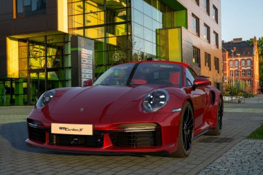 Porsche 911 Turbo S Cabriolet modern bir ofis binasının önüne park etmiş.