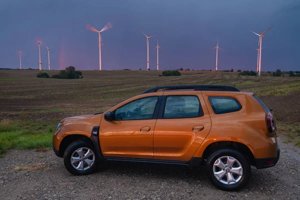 Suv Dacia Duster Tle Wieczornej Burzy Przelatującej Nad Farmą Wiatraków — Zdjęcie stockowe