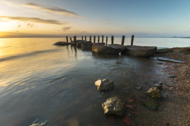 Sunrise, sahil, kayalar ve kazık sunrise düşünürken,