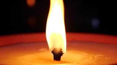 Mum alevi süper yavaş çekimde kapanıyor. Mum mezarda yanıyor. Mumlar mezarlıkta yanıyor. Karanlık bir arka planda yanan mum. 