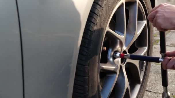 Cambio Rueda Coche Neumático Hombre Usando Llave Inglesa Para Atornillar — Vídeo de stock