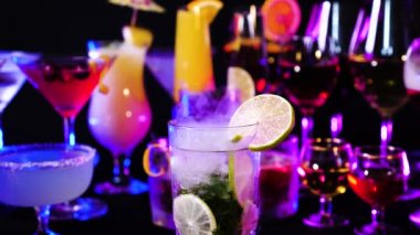 Mojito nane ve limonla bar tezgahında içilir. Barmen gösterisi ve kokteyl barında buzlu kokteyl hazırladı. Kuru buz dumanı etkisi olan bir barda renkli çeşitli içecekler..