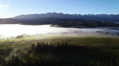 Sonbahar dağlarının havadan görünüşü. Güneşli, sisli bir sabah, destansı alp manzarası, sisle kaplı bir orman. Polonya, Avrupa 'daki Tatra dağlarının yüksek panoramik manzarası. Idyllic şafak sahnesi.