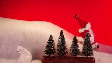 Noel Baba kızağına biniyor, kamera görüntülerini durdurun. Kırmızı arka planda Noel ağaçları olan bir Noel manzarası. Noel tatili kalp ısıtma ve komik animasyon.