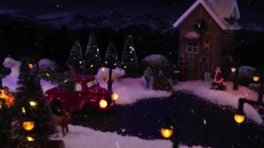 Noel ve Yeni Yıl 2021. Noel köyünde kar yağıyor, büyülü kış manzarası. Noel şenliği modeliyle film çekimini durdurun. Tatil selamları..