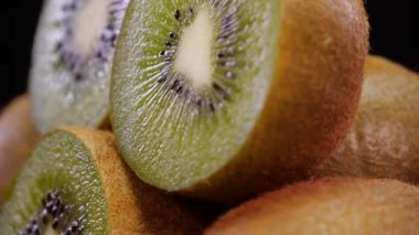 4K 'de siyah arka planda dönen Kivi meyveleri. Taze ve lezzetli kiviye yakın çekim, stüdyo görüntüleri..