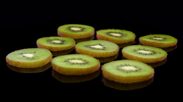 Snijwonden Van Groene Kiwi Draaiend Zwarte Achtergrond Kiwi Vruchtenschijfjes — Stockvideo