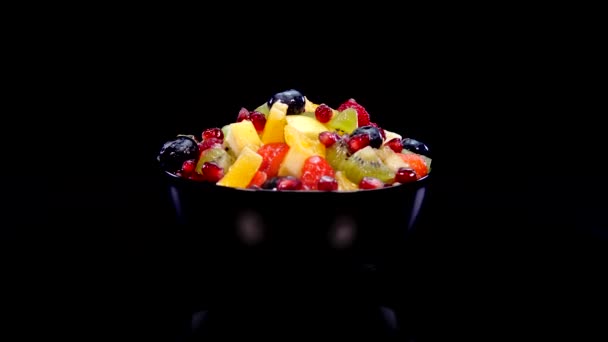 Salade Fruits Colorés Dans Bol Tournant Sur Fond Noir Gros — Video