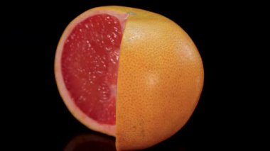 Siyah arka planda dönen pembe greyfurt, yakın görüş. Taze, mükemmel, organik greyfurt 4K. 