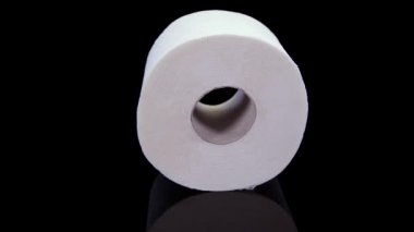 Tuvalet kağıdı siyah arka planda dönüyor. 4K 'da siyah arkaplanda izole edilmiş tuvalet kağıdı sunumu
