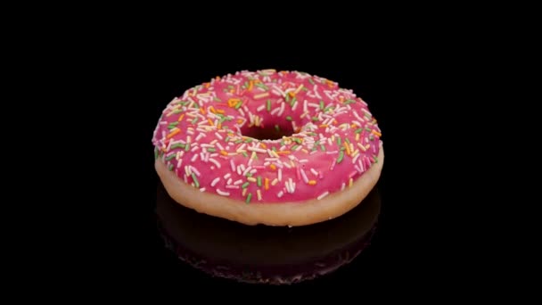 Donut Avec Glaçage Rose Saupoudrer Coloré Tournant Sur Fond Noir — Video