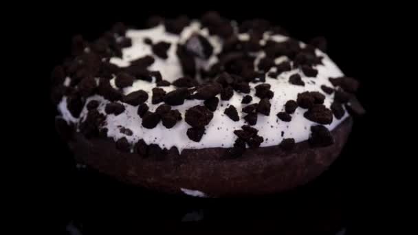 アイシングとクッキーでビテンドーナツは黒の背景で回転を振りかけます 霜降りで甘いドーナツと隔離された振りかける コンセプト 甘い食べ物 パン屋 ジャンクフード — ストック動画