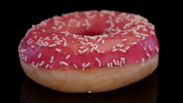 Donut Avec Glaçage Rose Saupoudrer Coloré Tournant Sur Fond Noir — Video