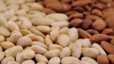 Badem fındıkları dönüyor. Organik ekolojik badem fıstıklarının soyut arka planı.