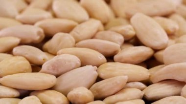 Badem fındıkları dönüyor. Organik ekolojik badem fıstıklarının soyut arka planı.