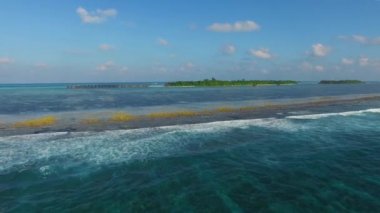 Hint Okyanusu 'ndaki tropik adanın havadan görünüşü. Okyanus dalgaları ve mavi göl. Maldivler 'deki Cennet Adası, Bora Bora, Mauritius, Seyşeller, Hawaii, Filipinler.