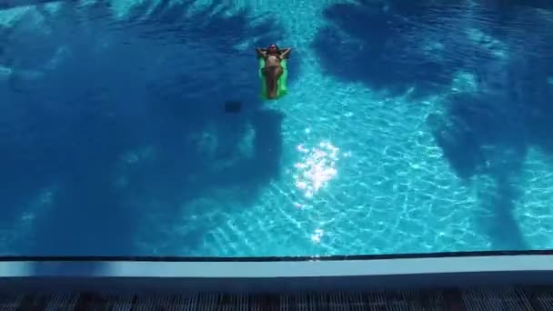 女孩或女人在游泳池床垫上晒日光浴的空中照片 热带假期在天堂与棕榈树 白色沙滩和绿松石水 豪华度假胜地的游泳池 — 图库视频影像
