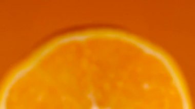 Portakal suyu yavaş çekimde yere düşer ve suya düşer. Sulu taze tropikal meyve, mükemmel narenciye..