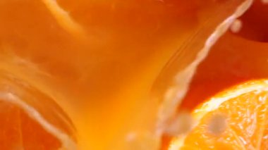 Portakallar yavaş çekimde yere düşüp portakal suyuna karışıyor. Sulu taze tropikal meyve, mükemmel narenciye..