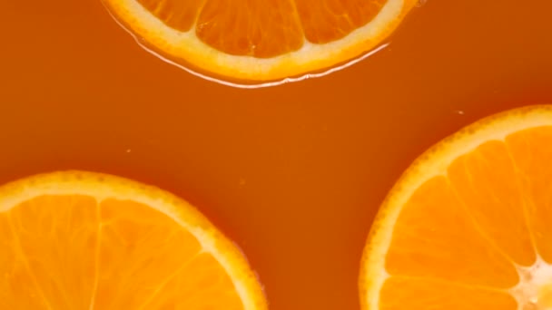絞りたてのオレンジジュースに浮かぶオレンジ 夏活気あるオレンジビデオ — ストック動画