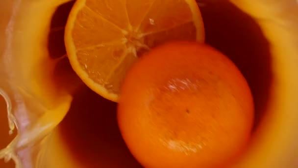 Apelsinen Faller Och Stänker Sig Apelsinjuice Och Delas Upp Halvor — Stockvideo