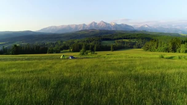 日の出の間に山の中でキャンプ 空中ビュー 高い山の景色を牧草地の真ん中に2つのテント タトラ山を背景に コンセプト 遊牧民 屋外旅行 野生へ ハイキング — ストック動画