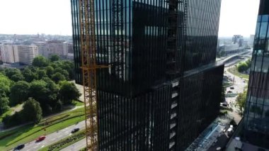 Modern, yüksek katlı cam bina yapım aşamasında, hava manzaralı. Avrupa 'da bir iş gökdeleninin inşaatı. Güzel bir ufuk çizgisi. Binaya bağlı Yüksek Turna Kulesi. 