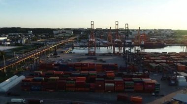 Gündoğumunda modern konteynır limanlarının havadan görüntüsü. Liman ve konteynır gemisi yükleme ve boşaltma. Lojistik ve ulaşım. Binlerce nakliye konteynırının görüntüsü.