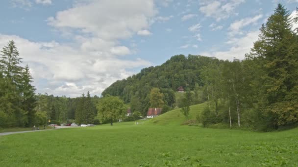 时间飞逝 云彩掠过山头 长满青草的山谷里典型的瑞士式房屋 — 图库视频影像