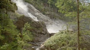 Dağlarda şelale. Ormandaki kayaların arasından akan su. Doğada hızlı akan hızlı dağ nehri. Suyun gücü. Nehir güçlü sularla dolup taşar. Simmenfall şelaleleri. - Simgesel. Bernese Oberland. Canton Bern. İsviçre.