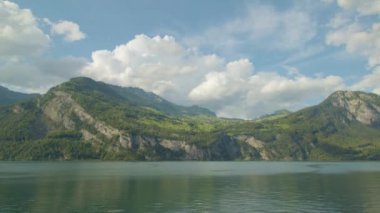 Göl kenarındaki dağları geçen bulutların zamanı. Çimenli dağ manzarası. Walensee 'de. Canton Glarus. İsviçre. 