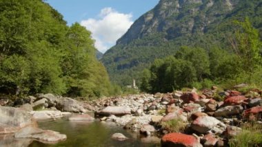 Dağ vadisinde taşlarla kaplı bulutların zamanı. Su taşların etrafında akar. Frasco, Valle Verzasca, Canton Ticino, İsviçre.