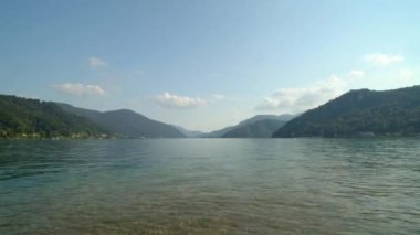 Arka planda dağlar olan bir gölün panoramik görüntüsü. Lugano Gölü, Canton Ticino, İsviçre.