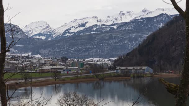 背景に雪の山とスイスアルプスの町の時間経過パノラマビュー ラウアー湖だ Seewen Canton Schwiz スイス — ストック動画