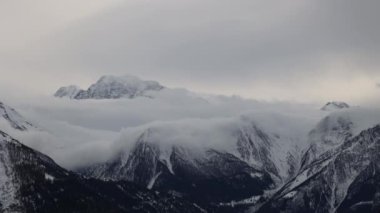 Dağların tepesinde dans eden bulutların zamanı. Kış dağı manzarası. Bettmeralp 'ten görüntü. Aletsch arenası. Valais Kantonu. İsviçre.