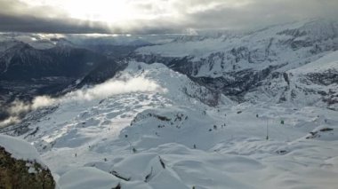 İsviçre Alplerinde kayak yapan insanların zaman çizelgesi. Karlı dağlarda panoramik manzara. Bulutlar karlı dağları geçiyor. Bettmeralp 'ten görüntü. Valais Kantonu. İsviçre.