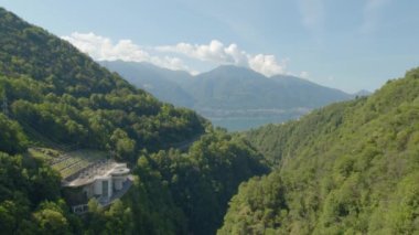 Contra Barajı 'nın yol, dağlar ve Maggiore Gölü' ndeki panoramik manzarası. Verzasca Barajı, Ticino Kantonu, İsviçre.