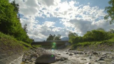 Zaman Akımı Suyu bir adamın kanalından akıyor. Su köprünün altındaki taşların etrafından akar. Alpnach, Obwalden Kantonu, İsviçre.