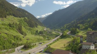 İsviçre Alplerinde Timelapse Otoyolu trafiği. Arabalar tünellerden dağların arasındaki köprülerden geçer. Wassen, Canton Uri, İsviçre.